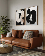Brown leather sofa in a living room with abstract art on the wall