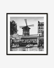 Framed black and white photo of Moulin Rouge in Paris with cars on the street.