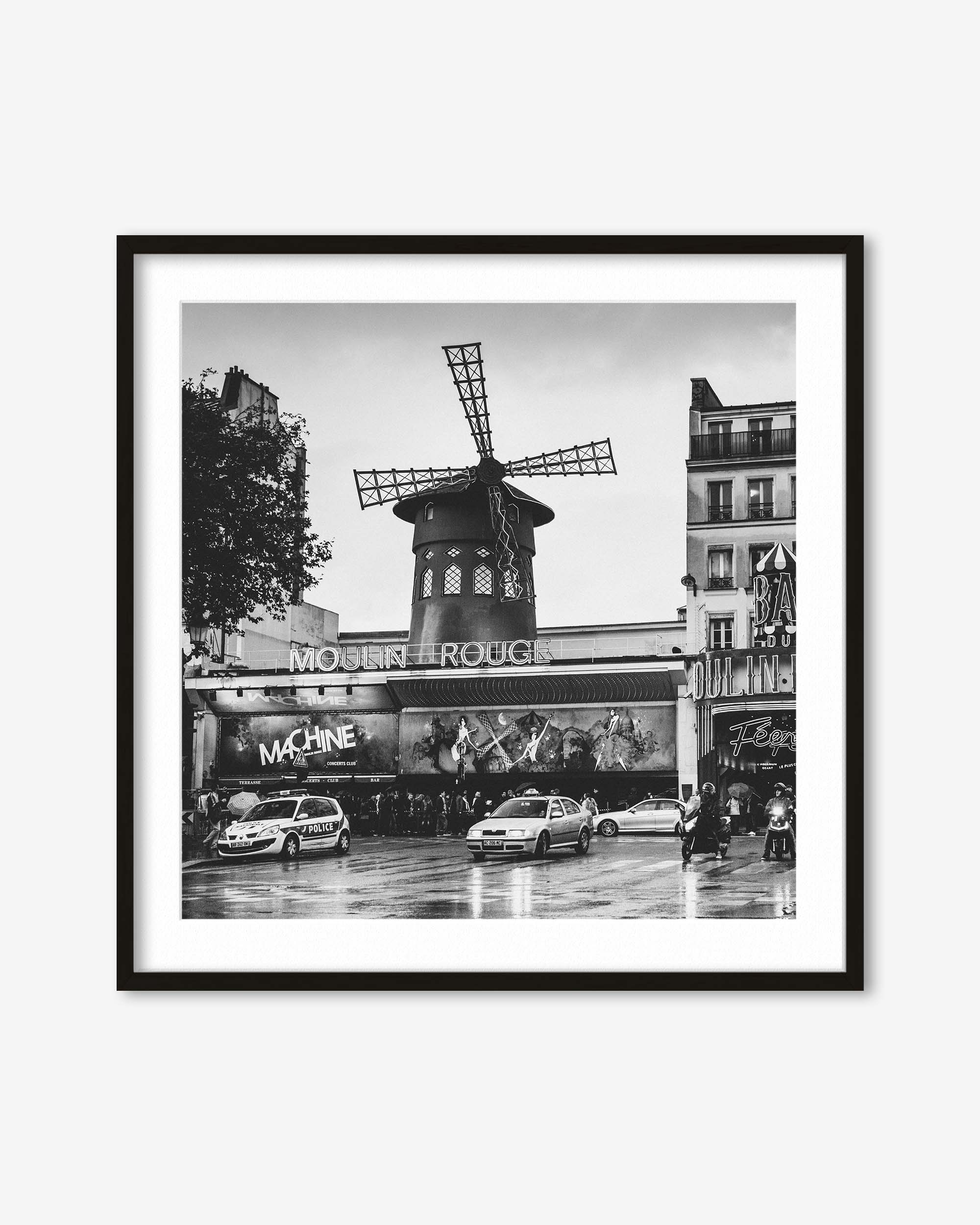 Framed black and white photo of Moulin Rouge in Paris with cars on the street.