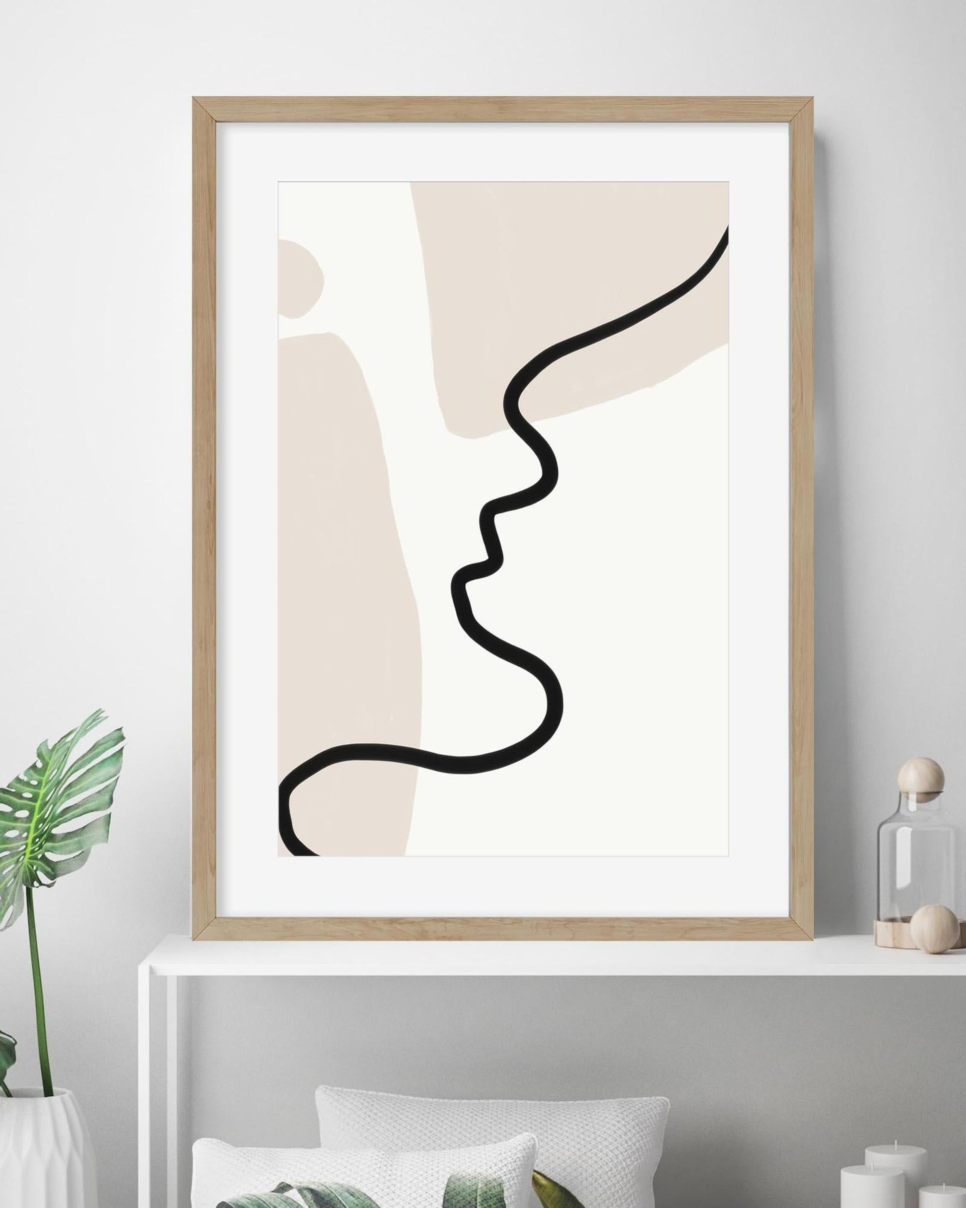 Framed abstract art print with a minimalist design on a wall.