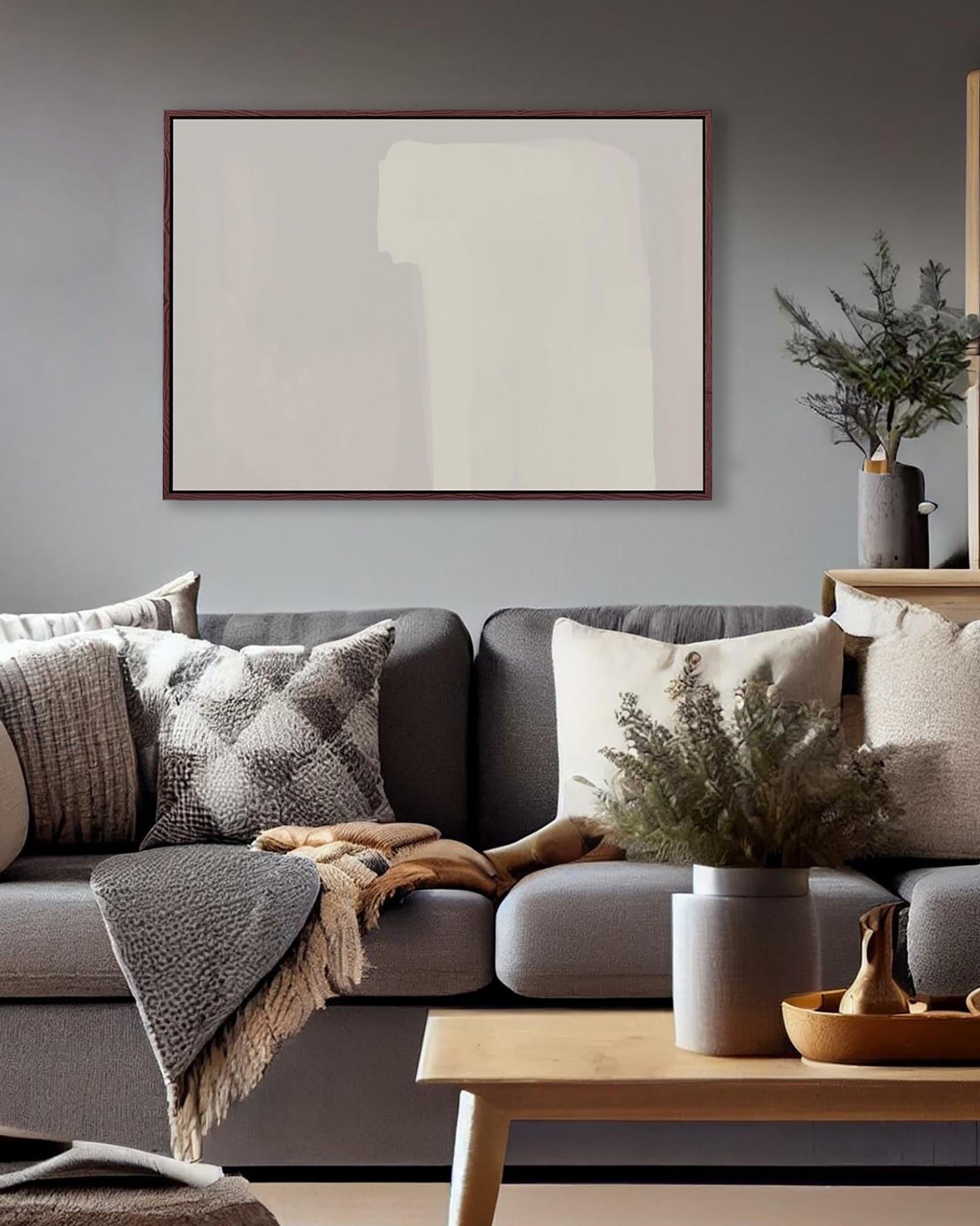 Living room with a gray sofa, abstract art, and decorative items.