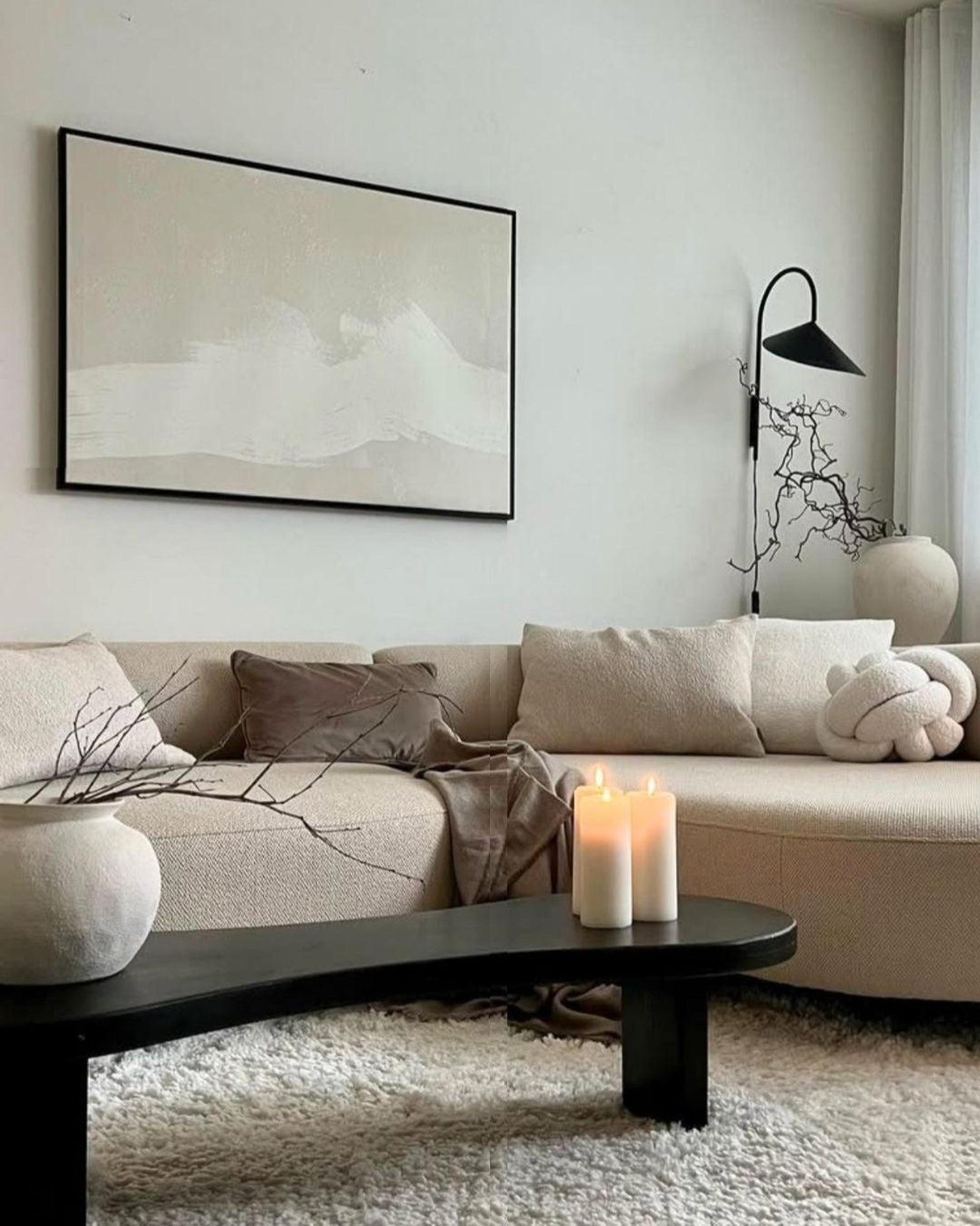 Cozy living room with a sofa, wall art, and candle holder.