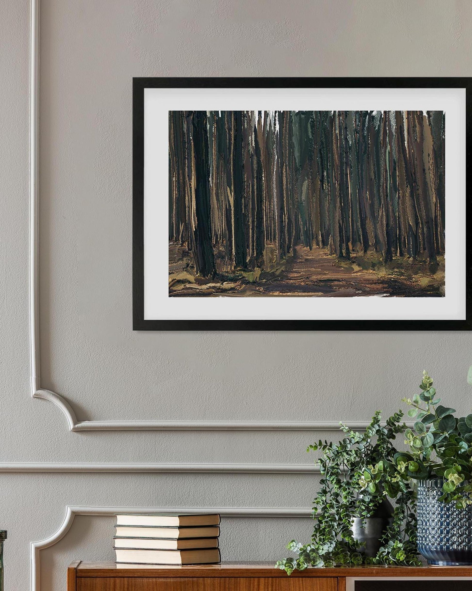 Framed painting of a forest scene on a wall above a console table with decorative items.