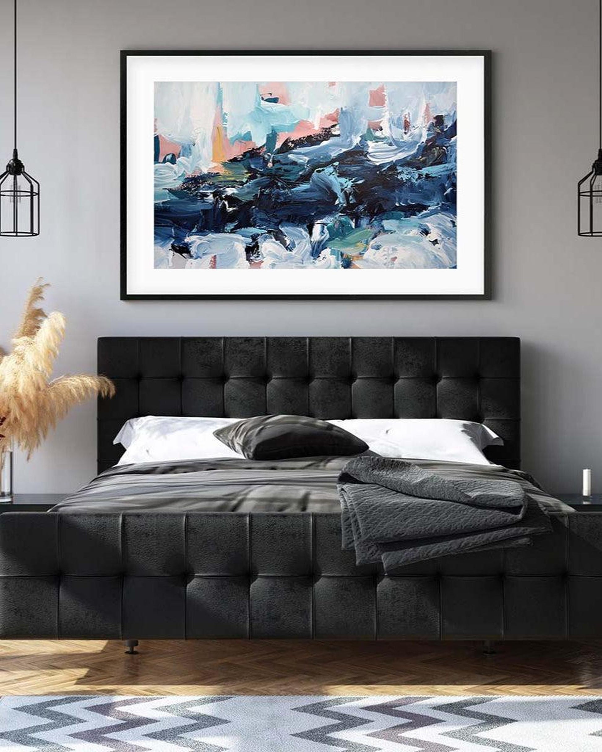 Modern bedroom with a tufted black bed, abstract painting on the wall, and decorative elements.