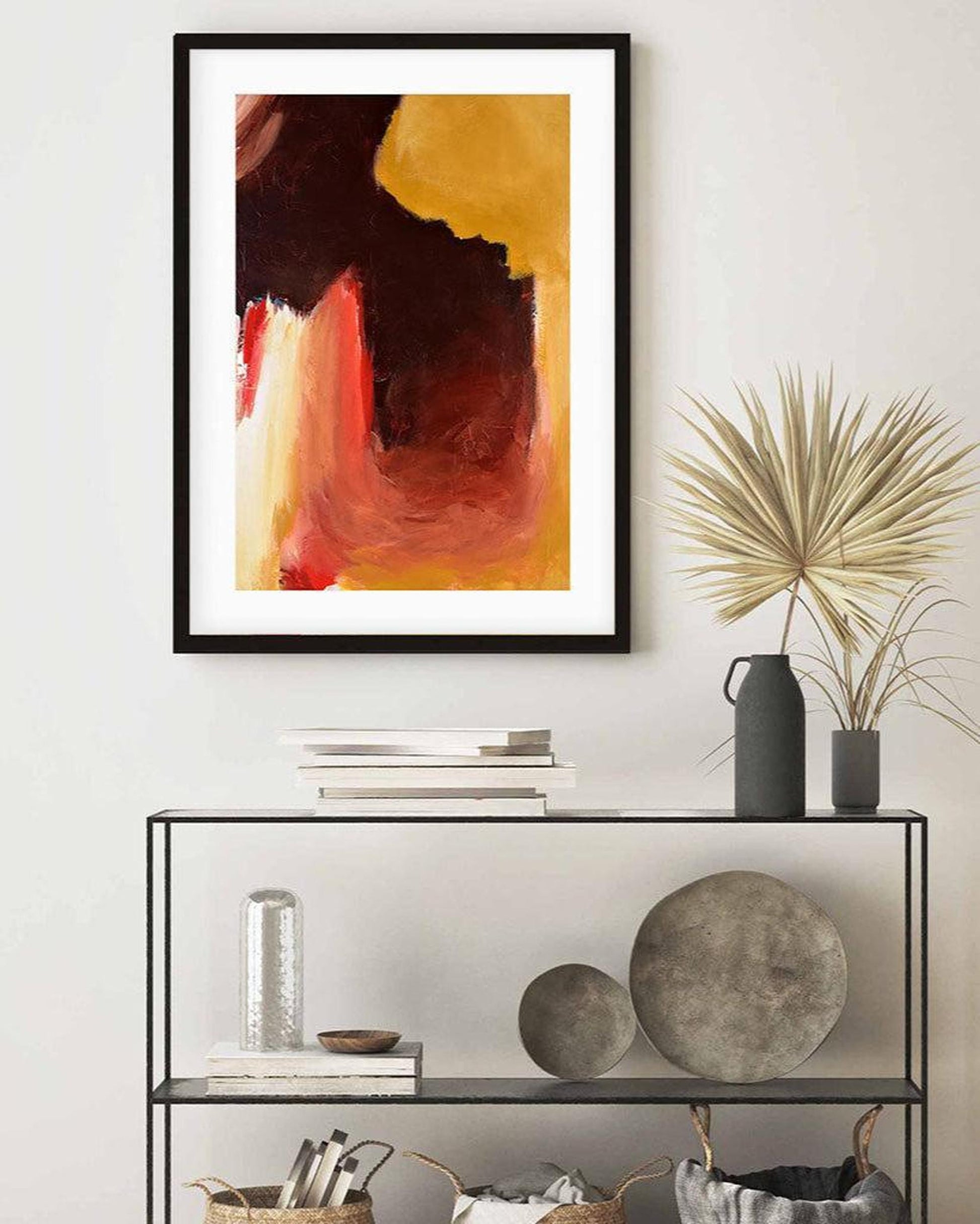 Abstract art print on a wall above a shelf with decorative items.