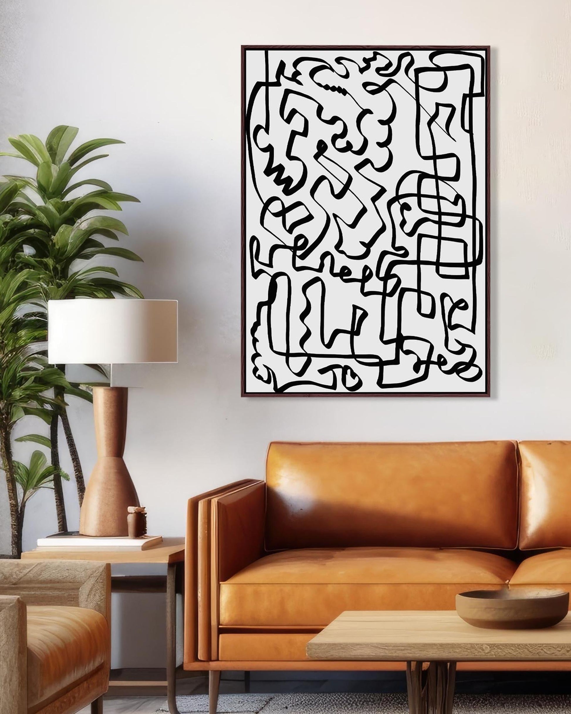 Abstract artwork on a wall above a brown leather sofa in a living room.