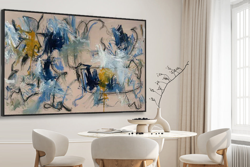 Abstract painting in a modern dining room with white chairs and a round table.