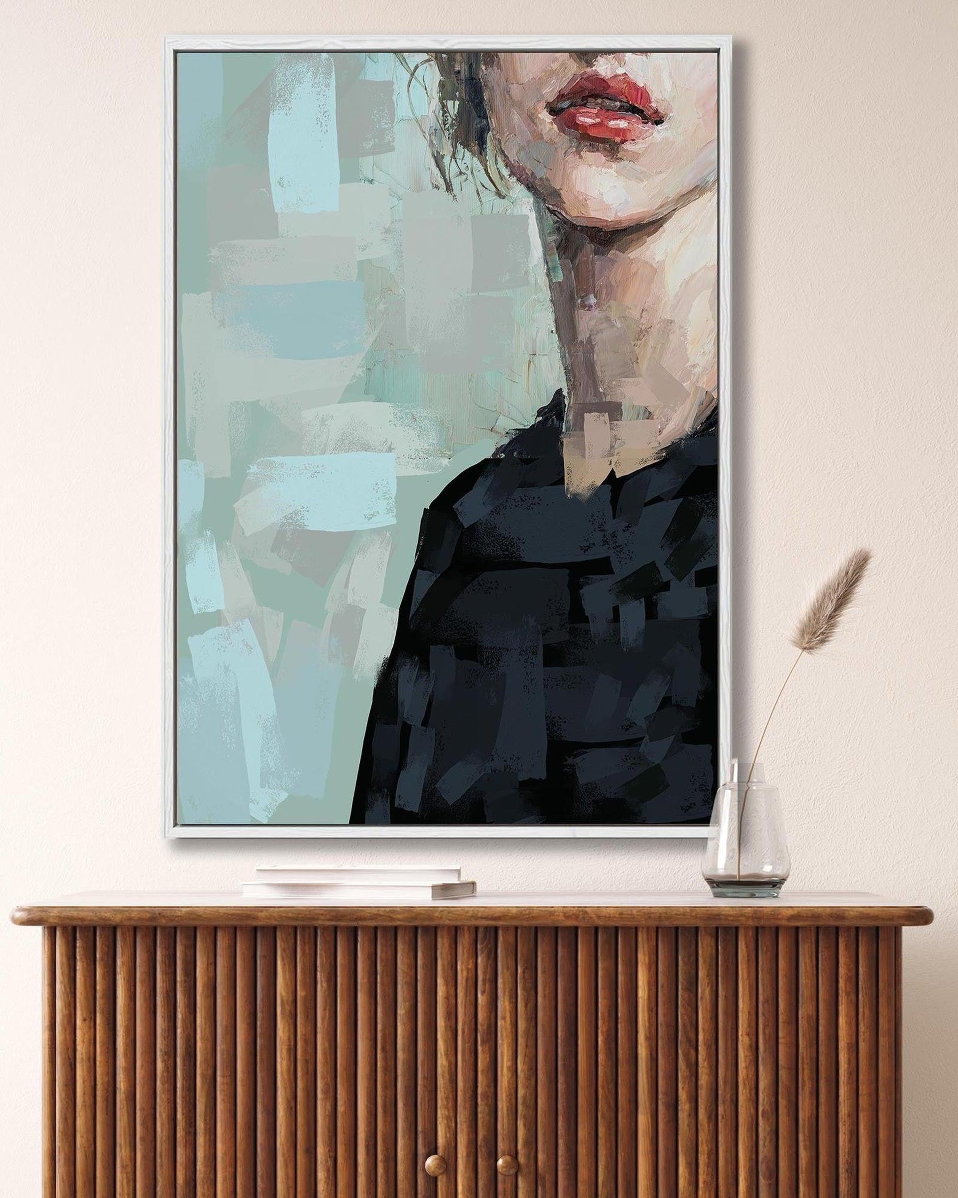 Framed abstract art print on a wall above a wooden cabinet.