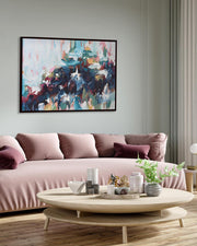 Modern living room with a pink sofa, round wooden coffee table, and abstract painting on the wall.