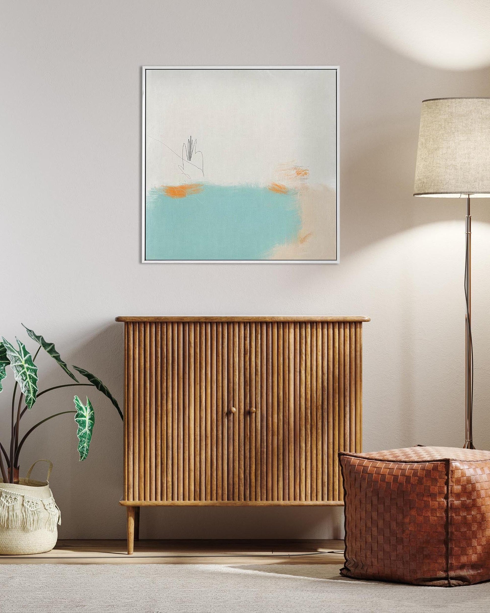Wooden cabinet with abstract painting, plant, and lamp in a room setting