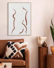 Living room with brown sofa, decorative pillows, abstract art, and a potted plant.