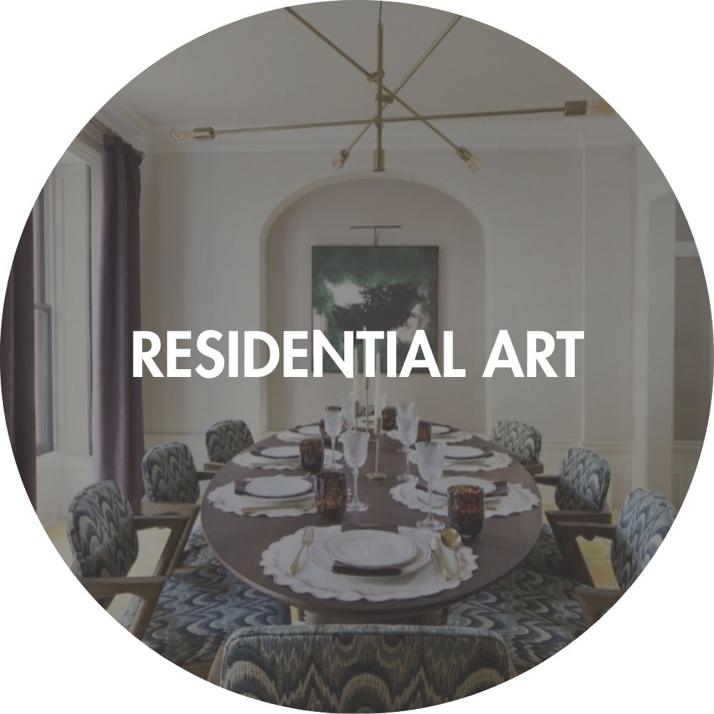 Dining room with a round table set for dinner, featuring a chandelier and framed artwork on the wall in residential interior design project.