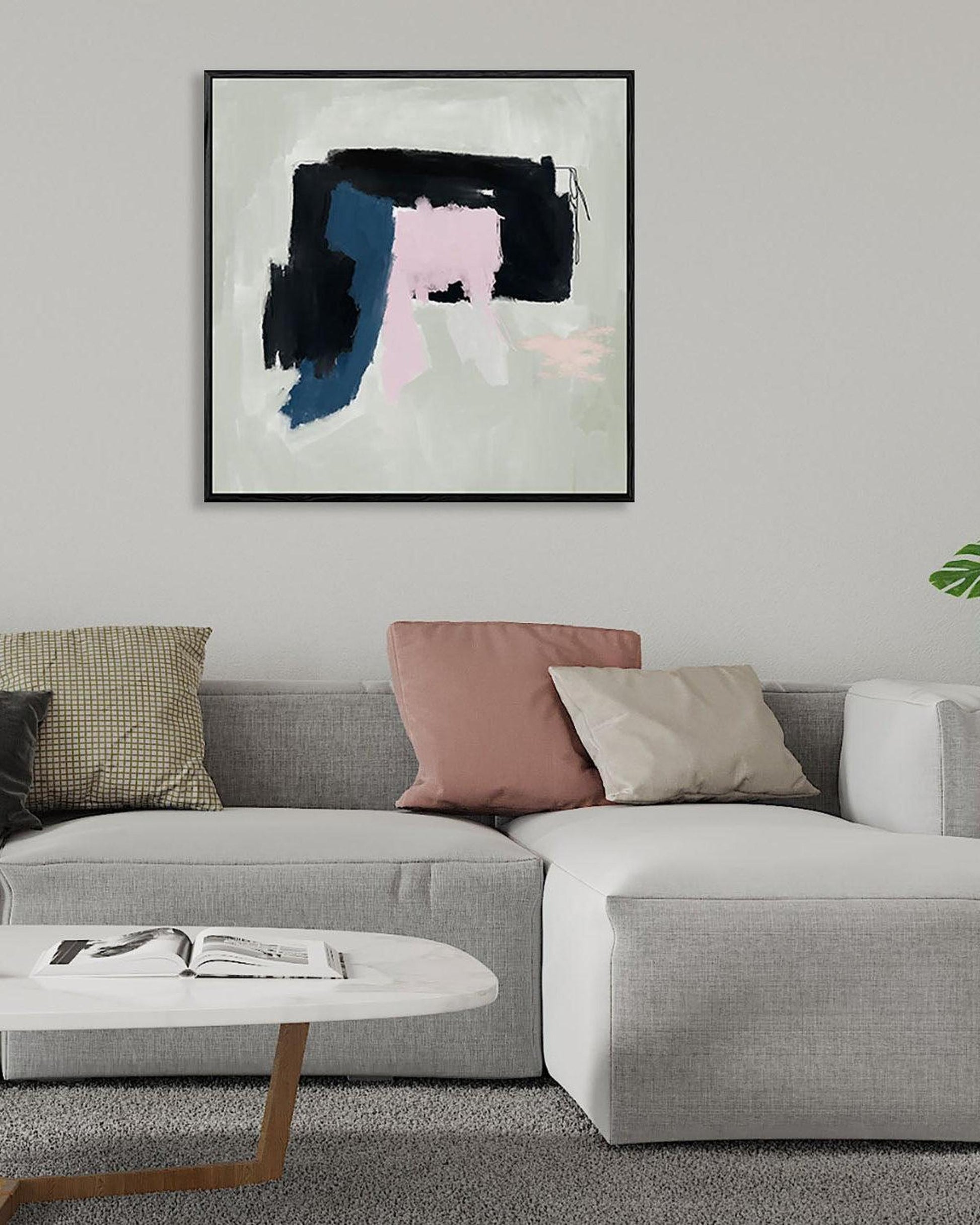 Living room with a gray sectional sofa, colorful pillows, and abstract art on the wall.