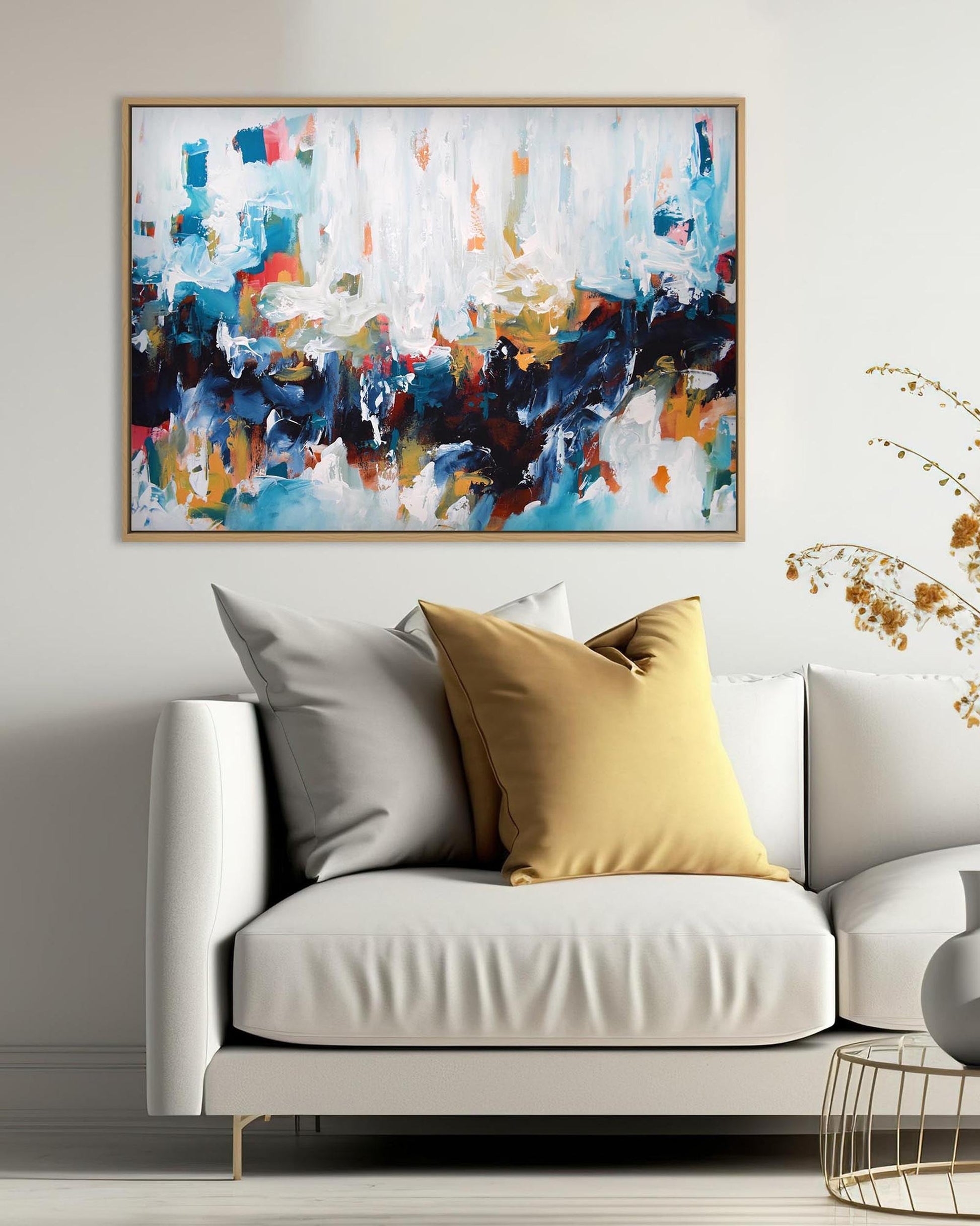 Modern living room with a white sofa, abstract painting, and decorative elements.
