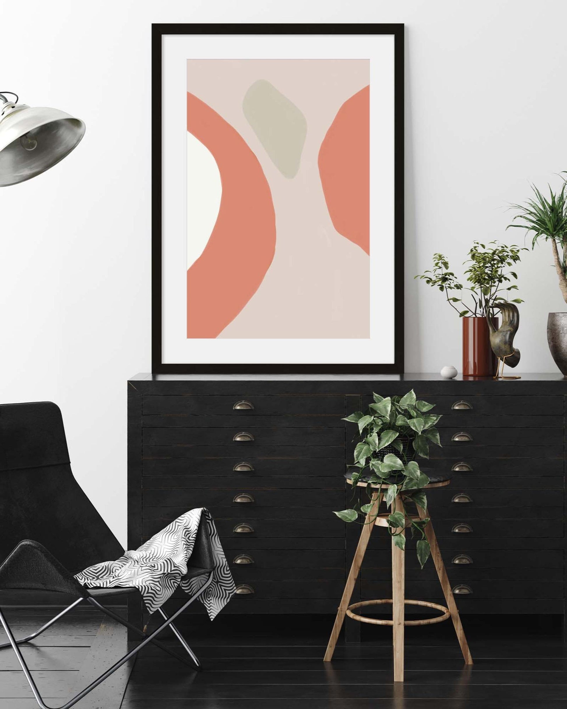 Modern interior with abstract art, black dresser, and decorative chair.