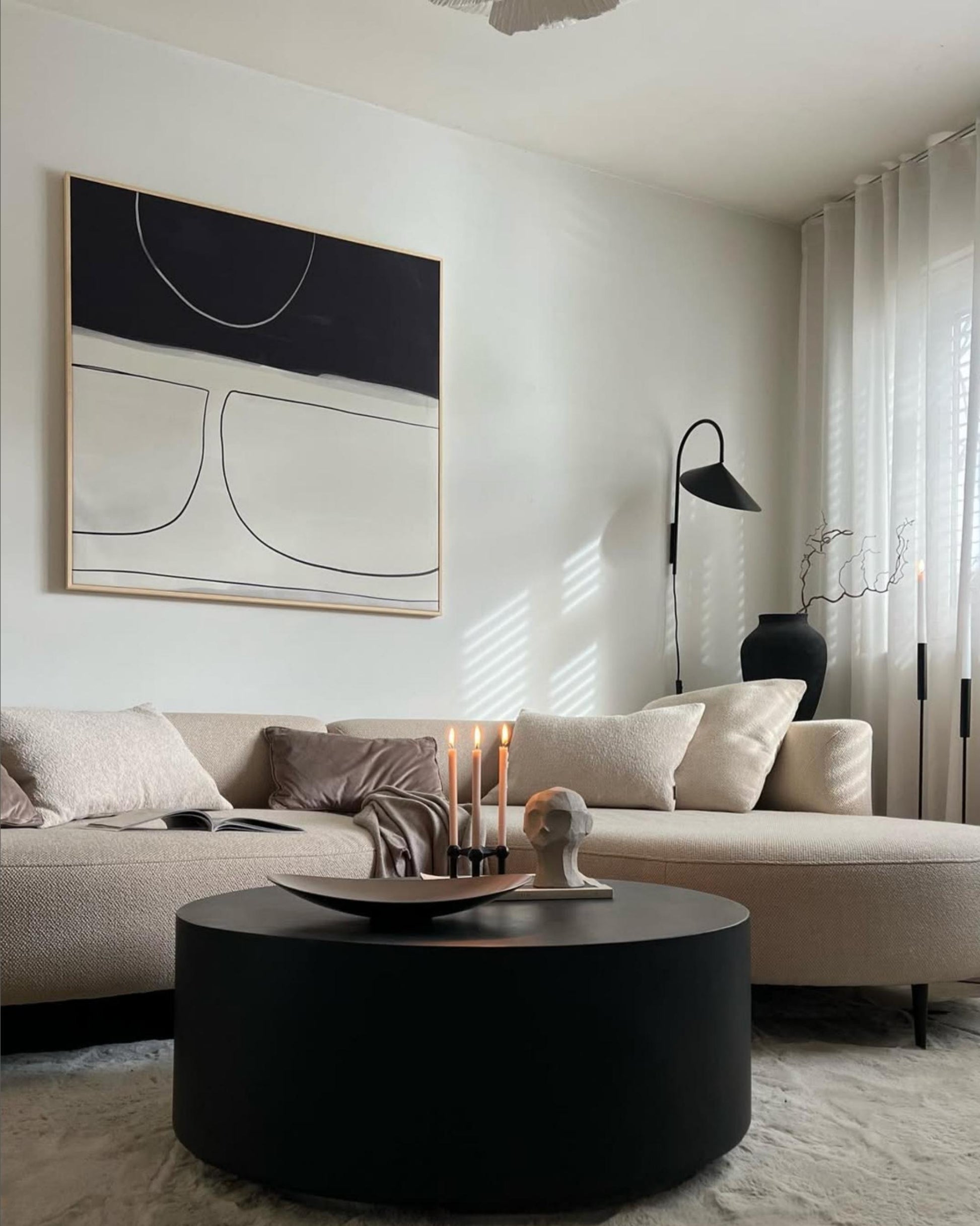 A modern grey framed canvas with abstract art hanging on a living room wall, complementing the minimalistic decor.