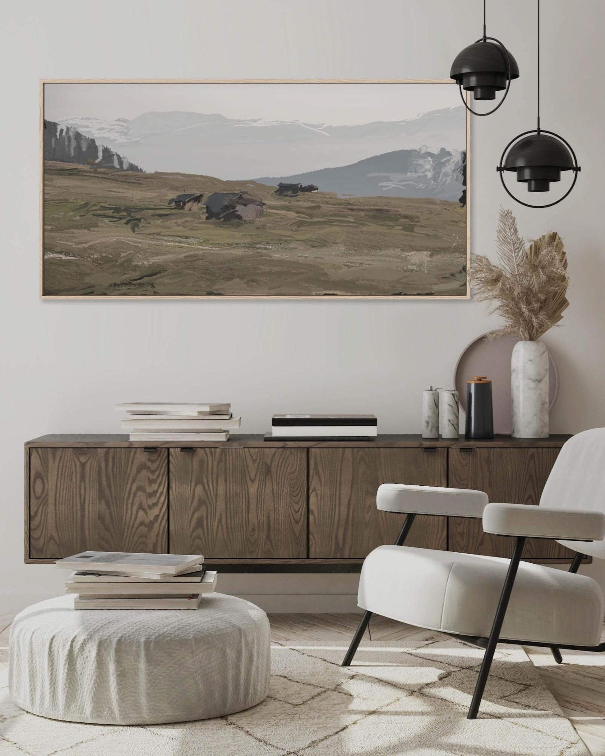 A framed canvas painting depicting a landscape with mountains and a forest, hanging on a wall in a room with modern decor.