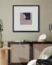 Framed artwork on a wall above a console table with decorative items.