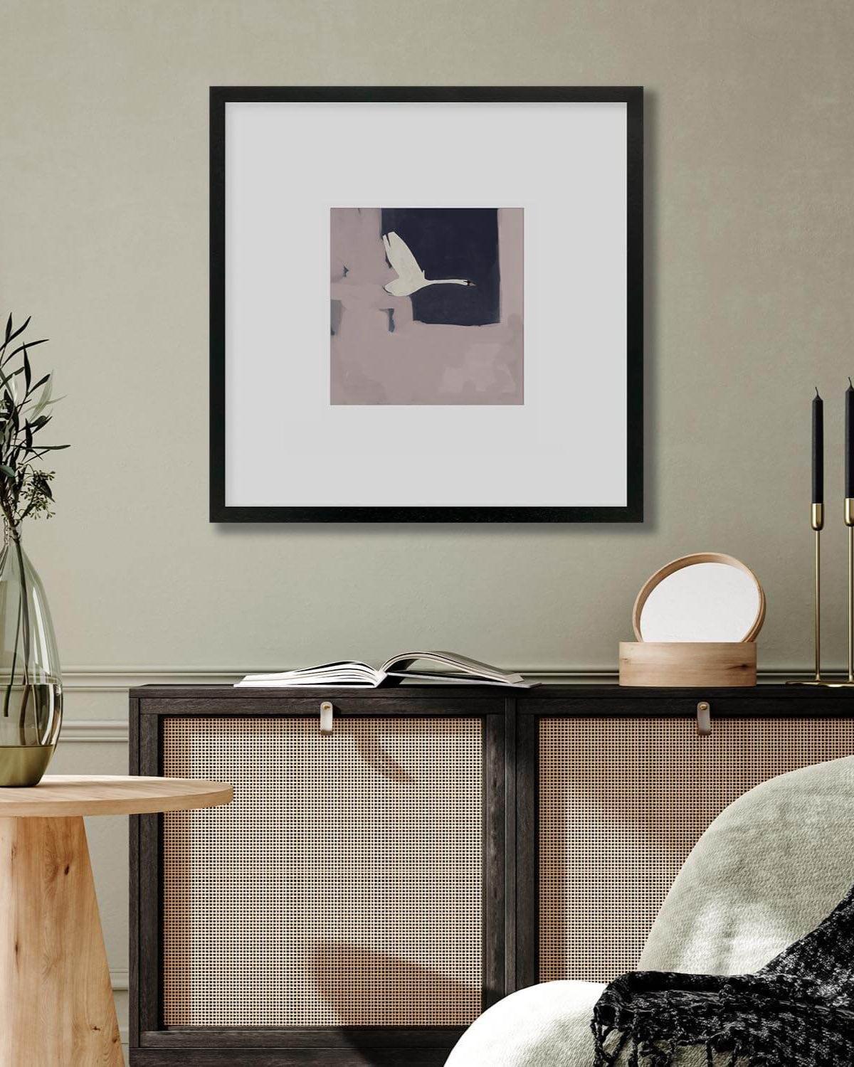 Framed artwork on a wall above a console table with decorative items.