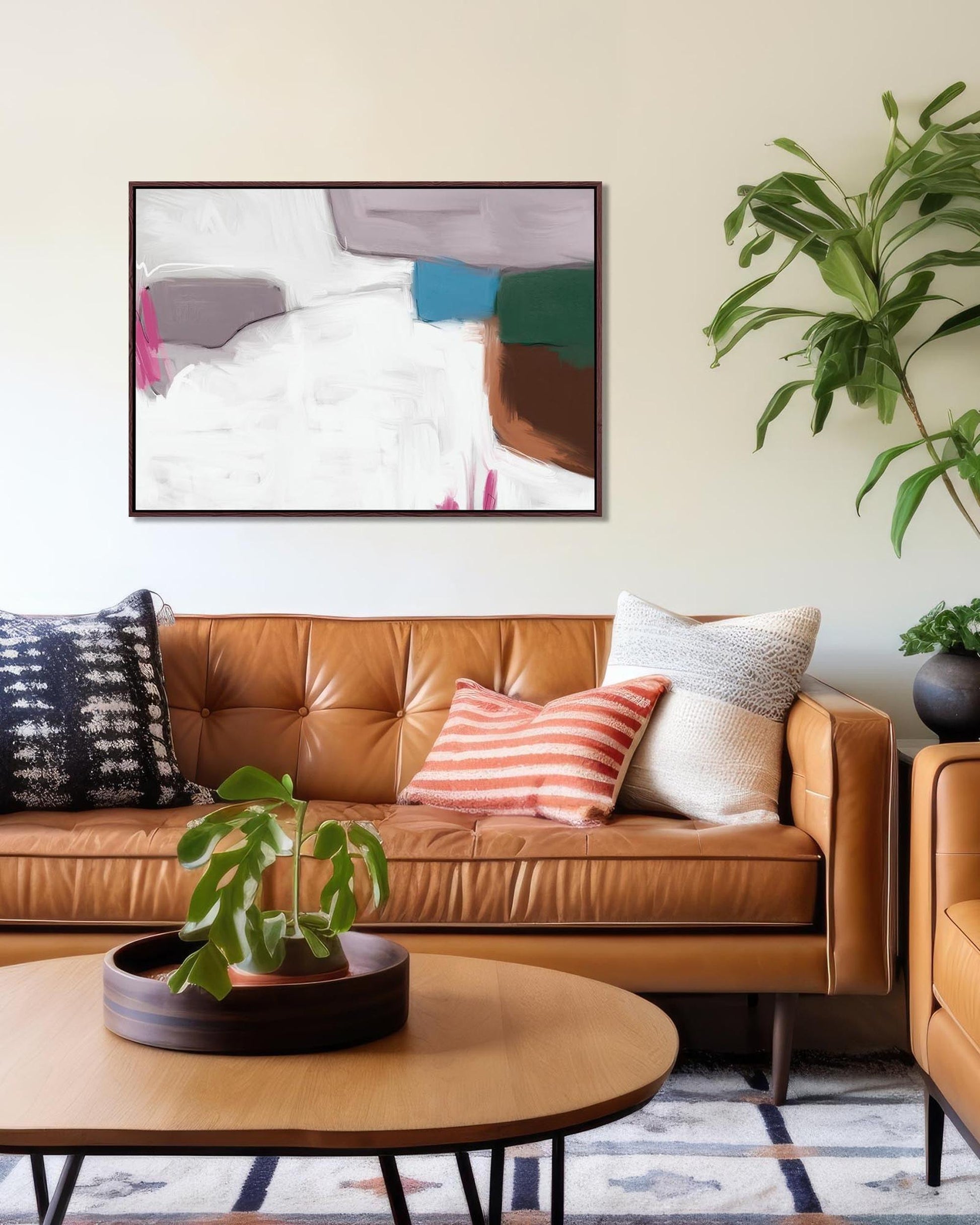 Living room with brown leather sofa, colorful pillows, and abstract art on the wall.
