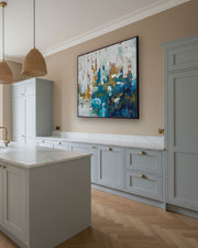 Modern kitchen with light gray cabinets, marble countertops, and a abstract painting on the wall.