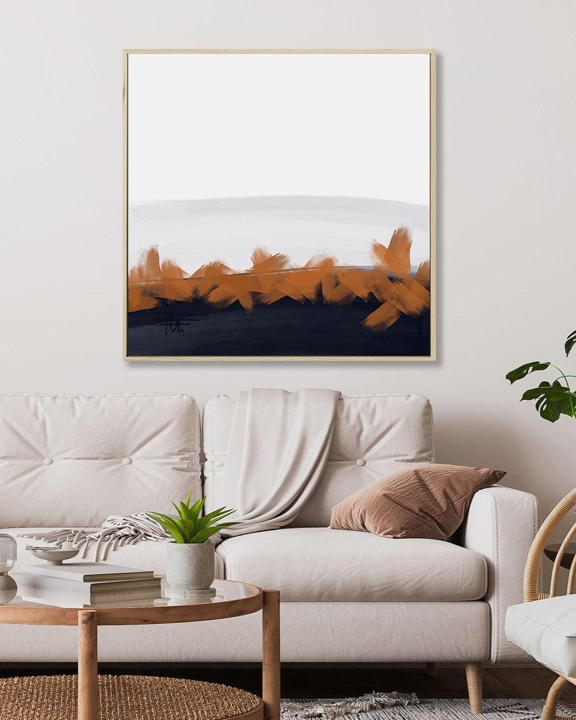 Modern living room with a white sofa, coffee table, and abstract art on the wall.