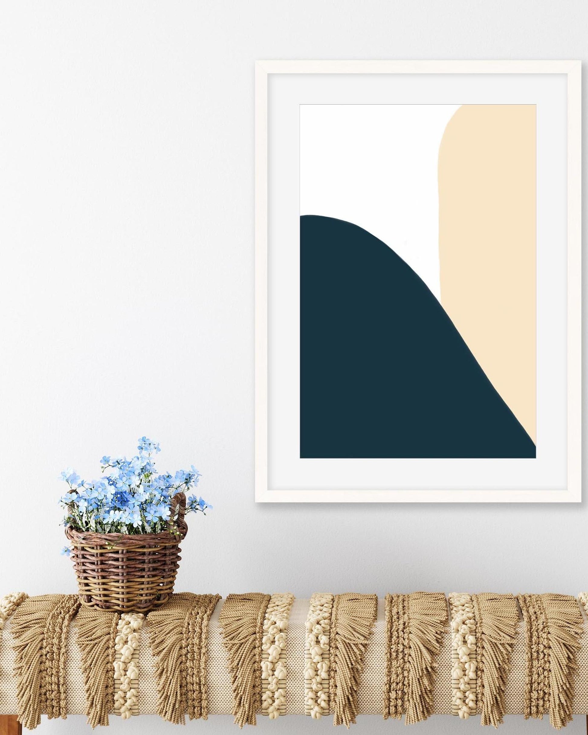 Framed abstract art piece with geometric shapes on a wall above a textured surface.