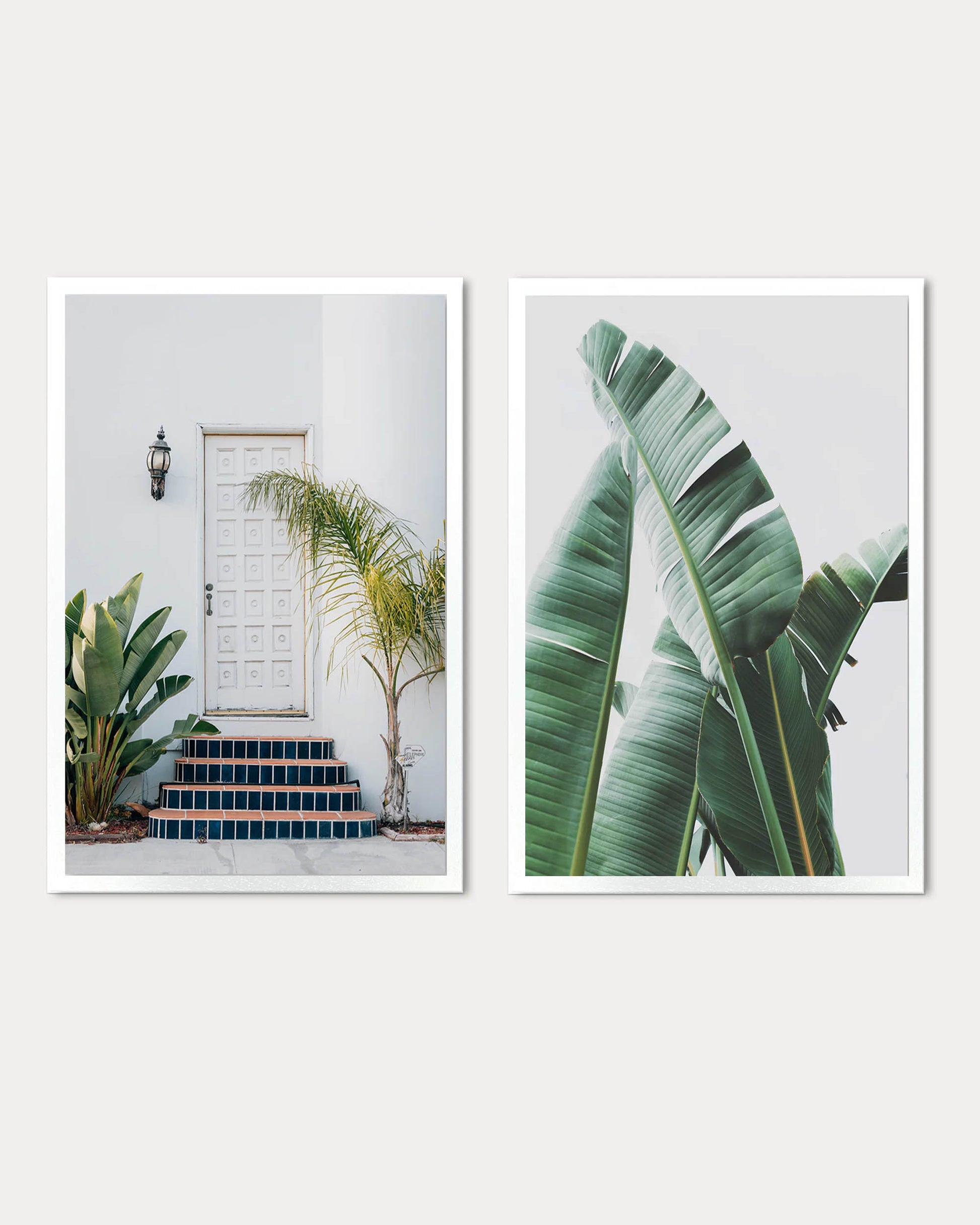 Two framed prints of a tropical scene with a white door, steps, and banana leaves.