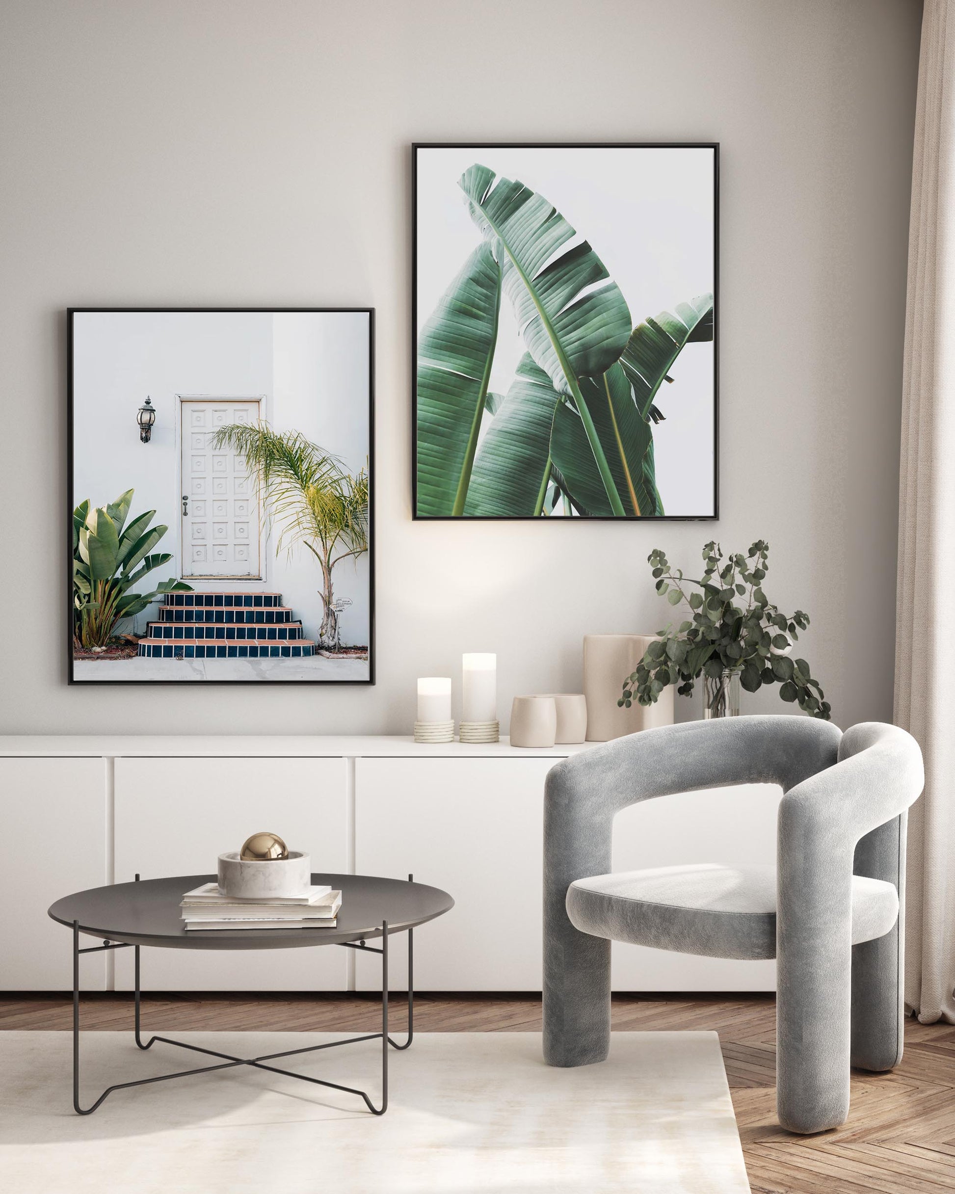 Modern living room with gray armchair, round coffee table, and plant-themed wall art.