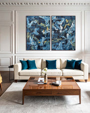 Modern living room with a beige sofa, wooden coffee table, and abstract blue artwork on the wall.