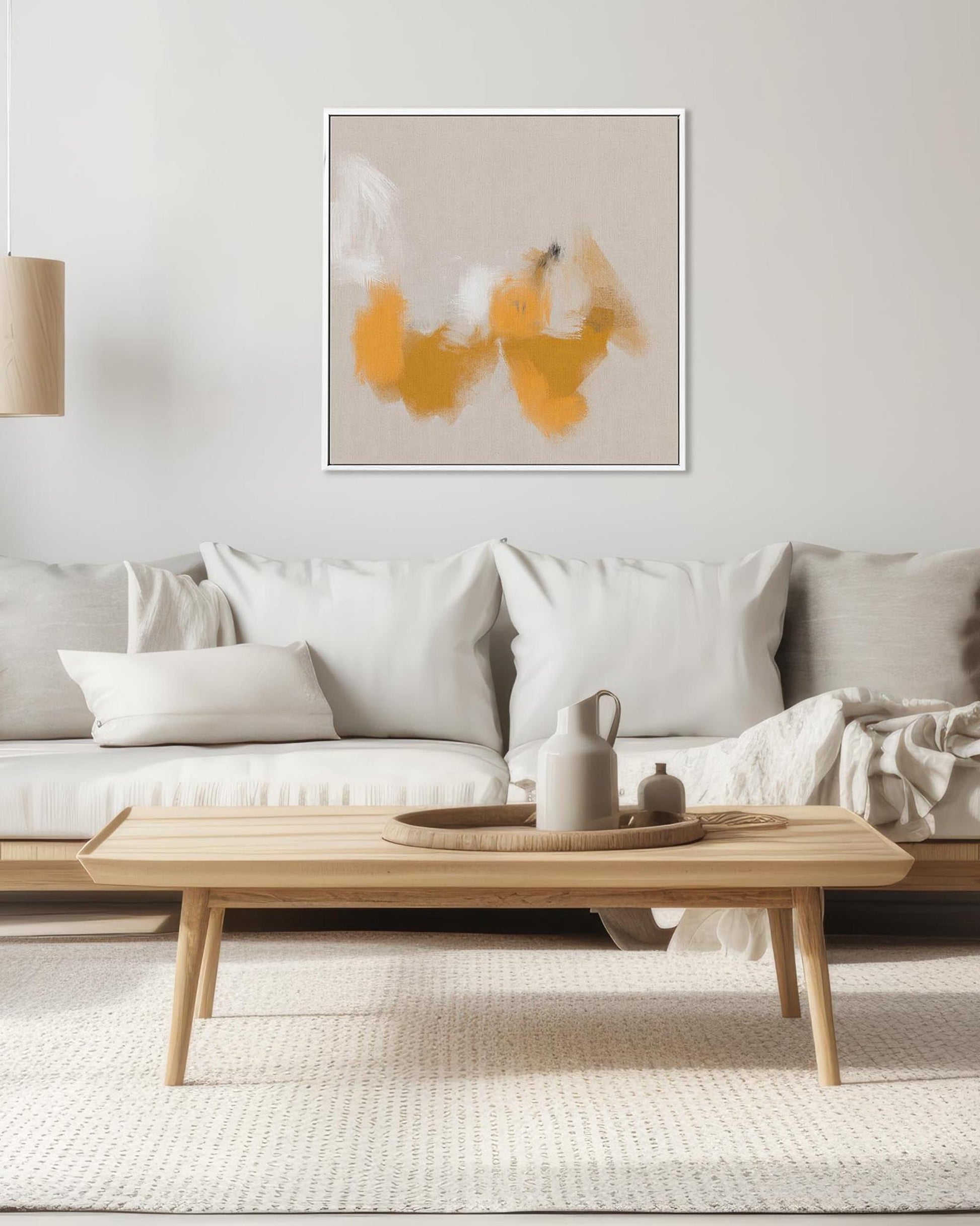 Modern living room with a wooden coffee table, white sofa, and abstract art on the wall.