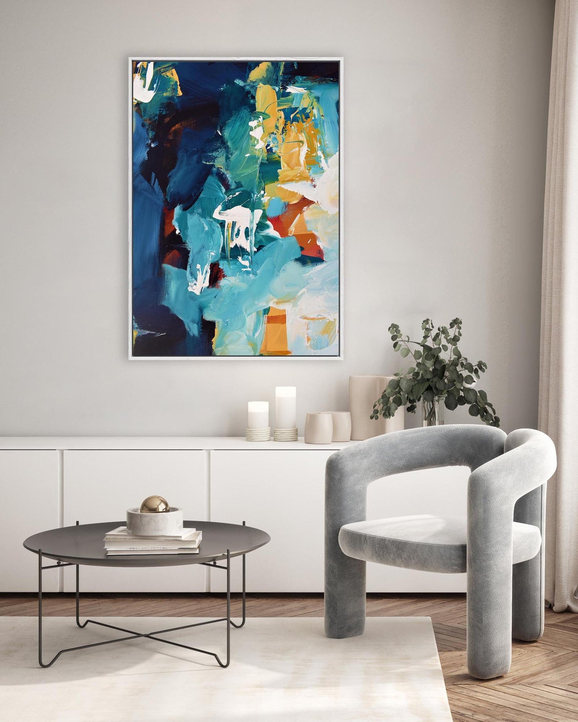 Modern living room with abstract art, gray chair, and round coffee table.