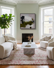 Modern living room with white furniture, marble coffee table, and abstract art on the wall.