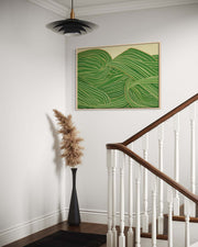 Staircase with a green abstract painting on the wall, a black vase with dried plants, and a wooden handrail.