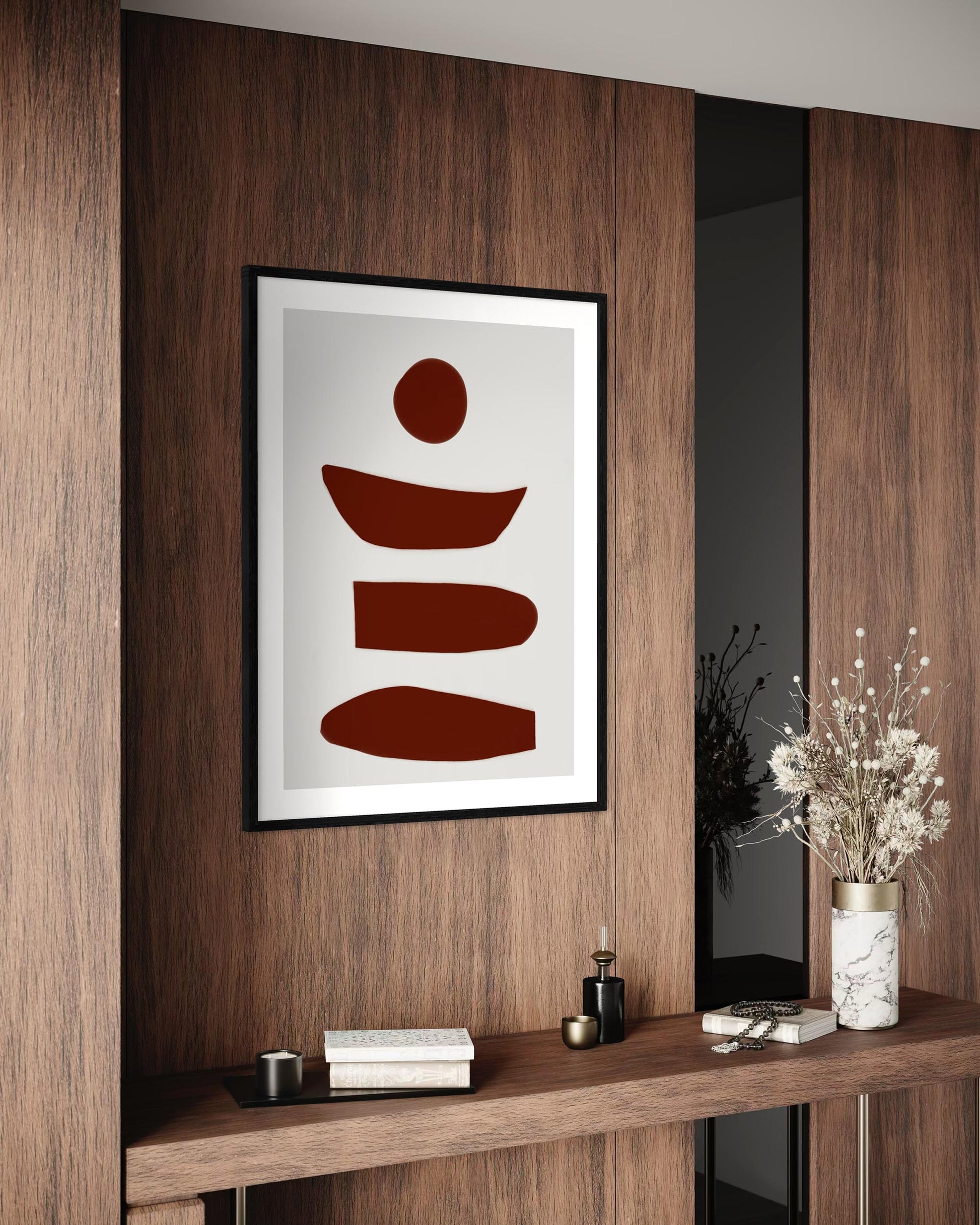 Framed abstract art piece on a wooden wall with decorative items below.