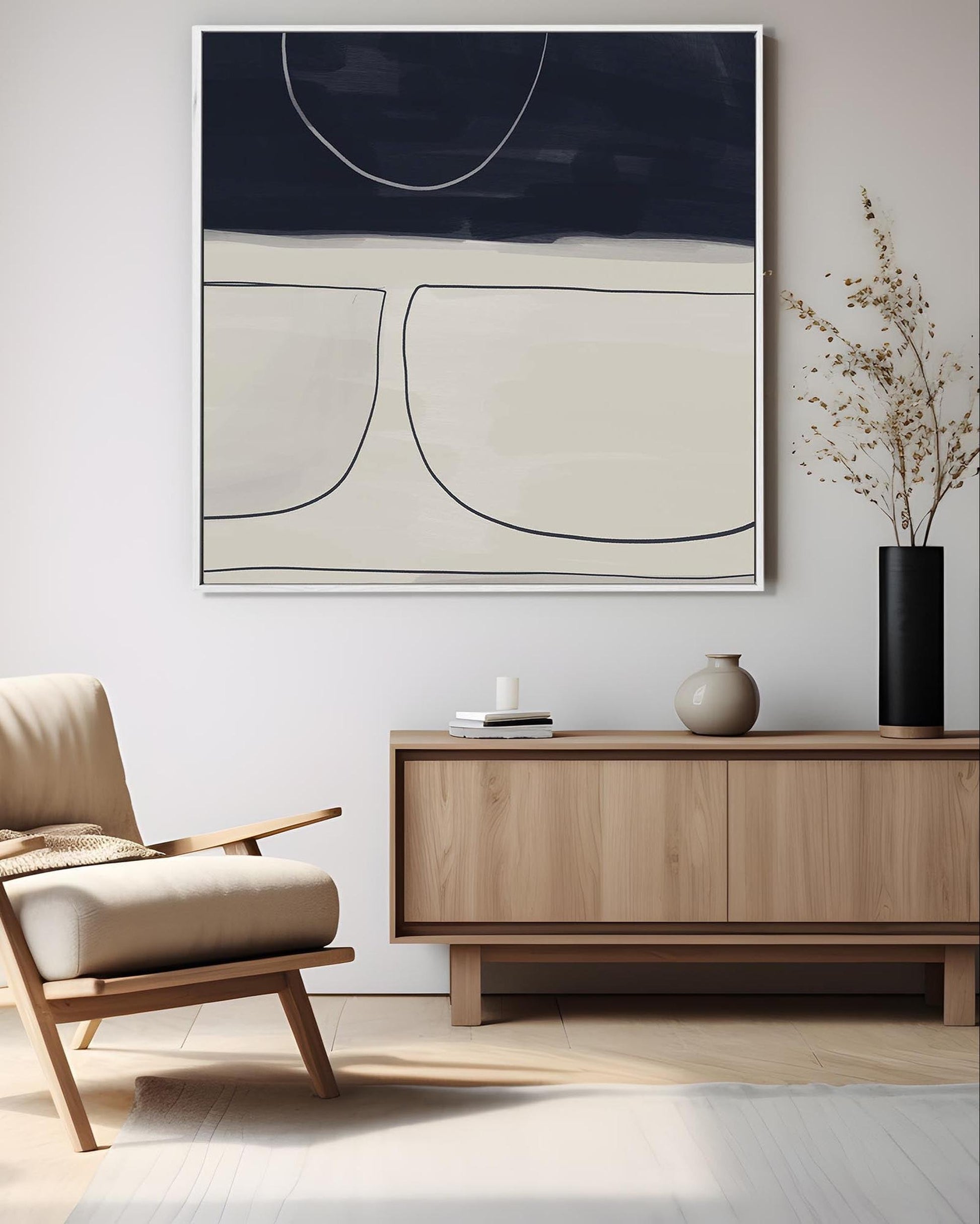 Modern living room with a beige armchair, wooden sideboard, and abstract art on the wall.