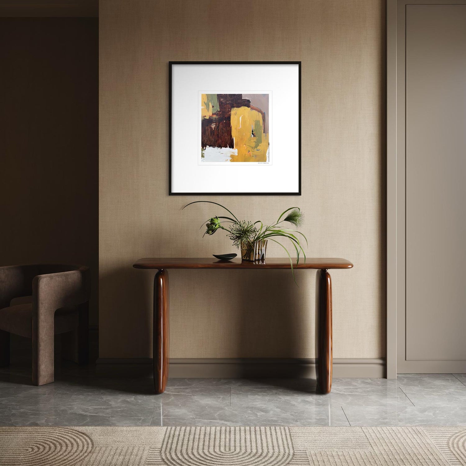 A framed abstract art print with yellow, brown, and white tones hangs on a beige wall above a wooden console table with a plant in a modern interior setting.