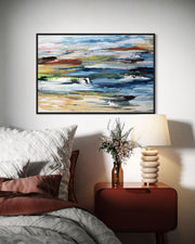Abstract painting on a wall above a bed with a nightstand and lamp.