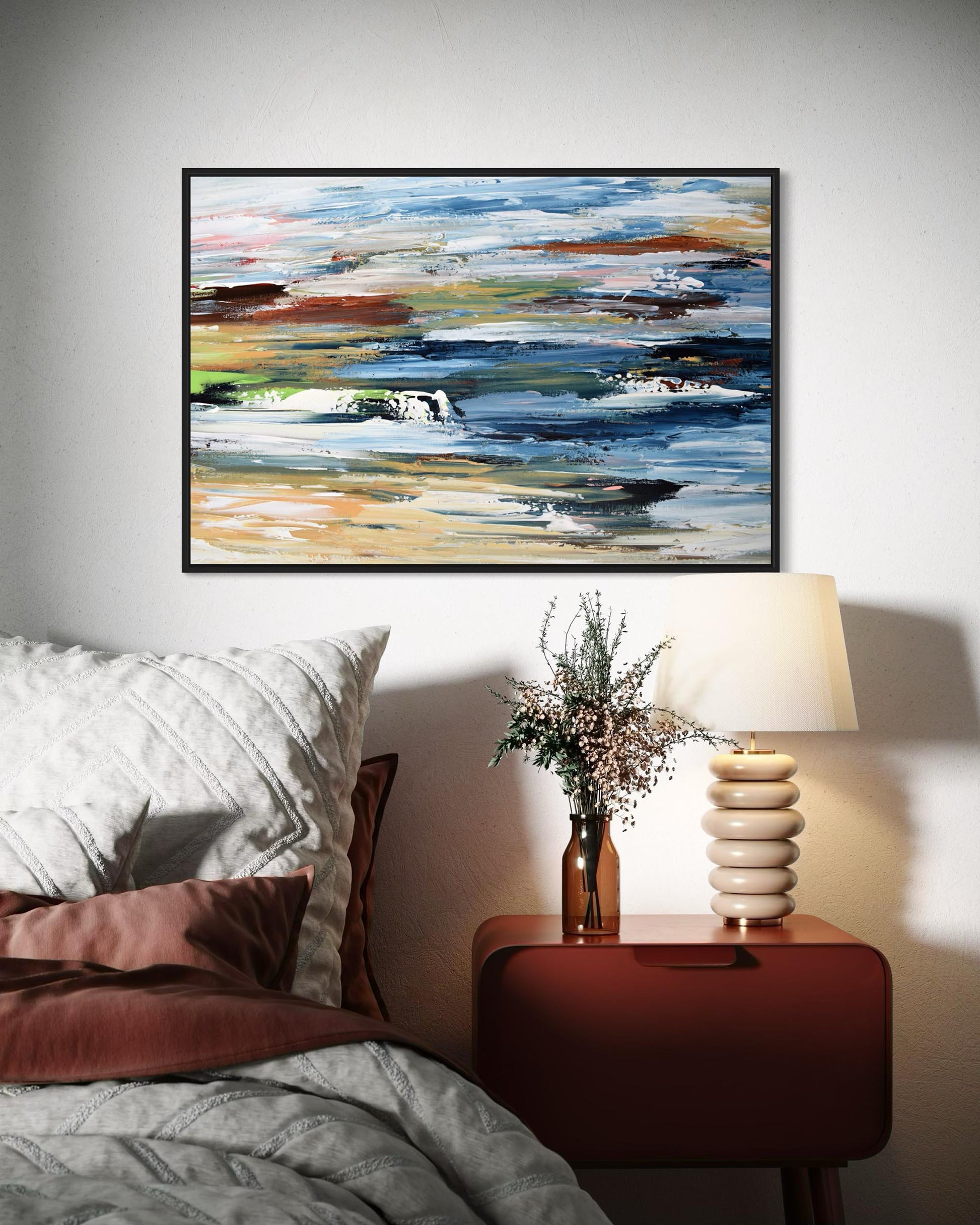 Abstract painting on a wall above a bed with a nightstand and lamp.
