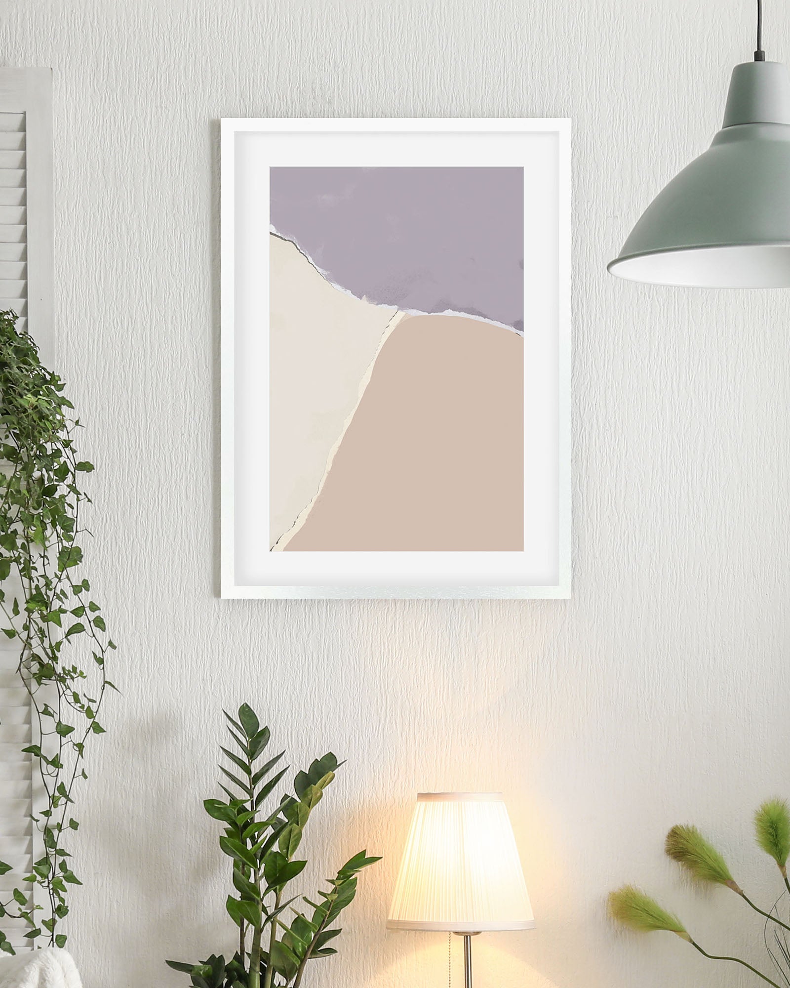 Framed abstract art print on a wall with plants and a lamp in the background