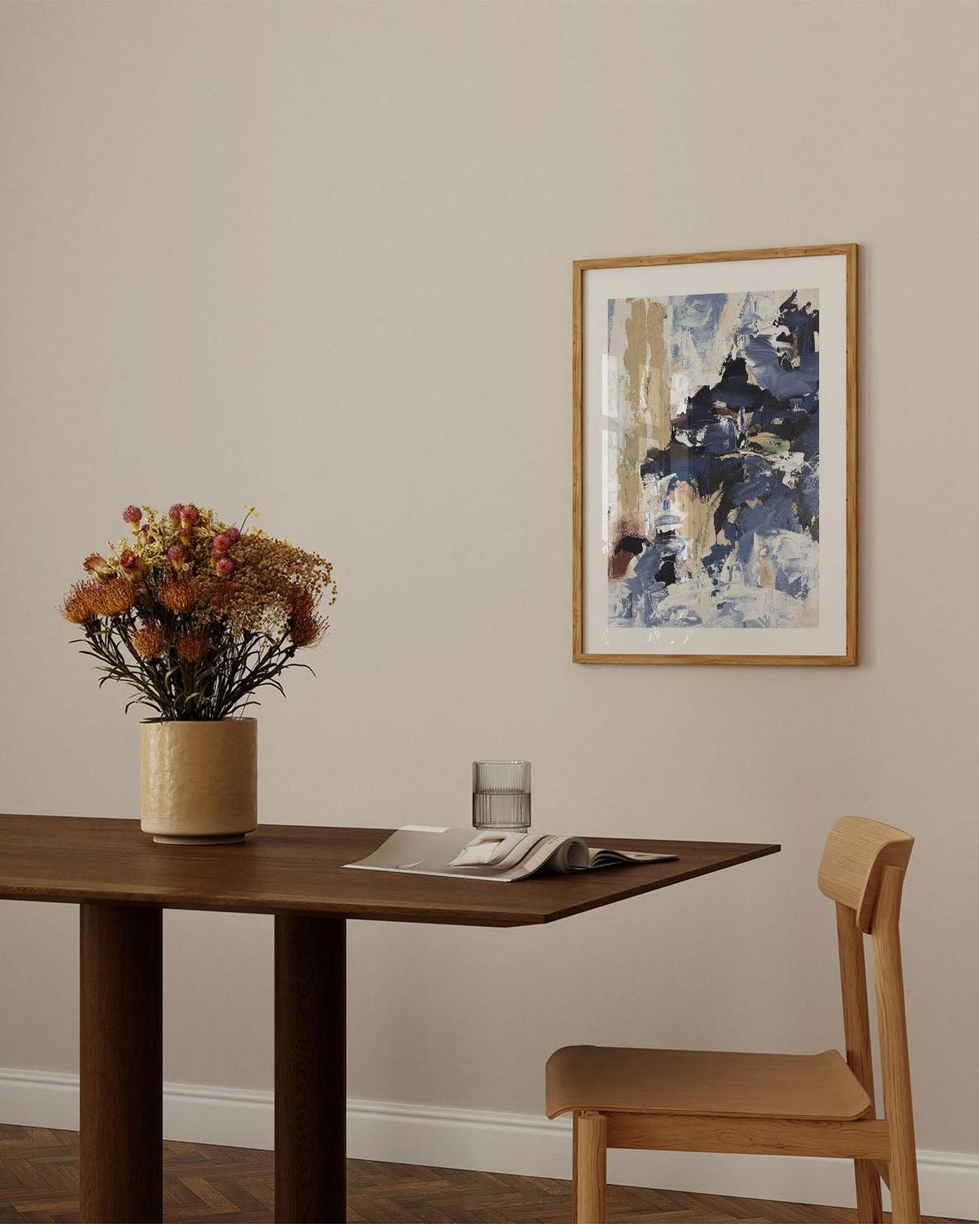 Dining room with wooden table, chair, and abstract painting on the wall.