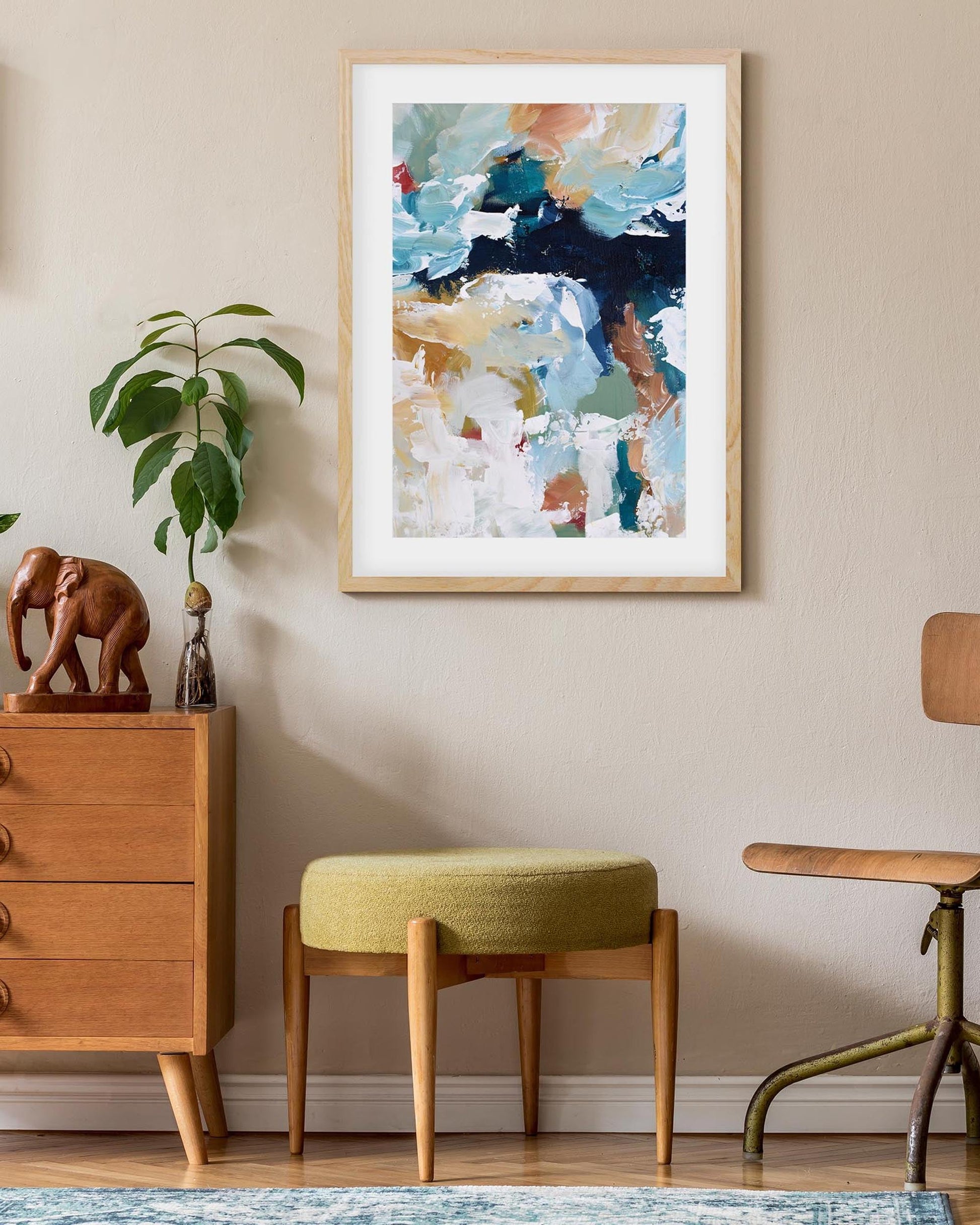 Room interior with a wooden dresser, abstract art, and decorative items.