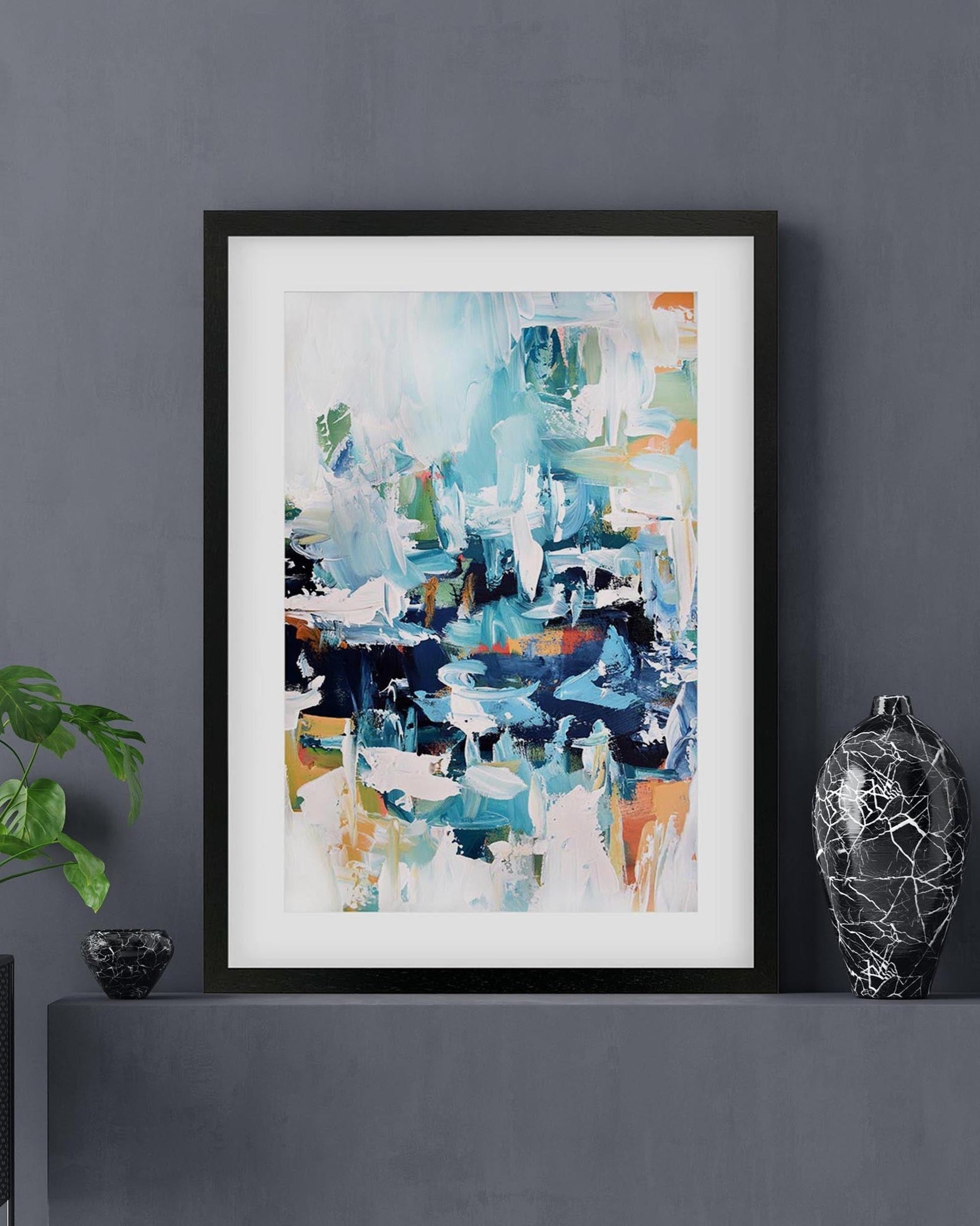 Framed abstract art print on a dark wall with decorative elements.