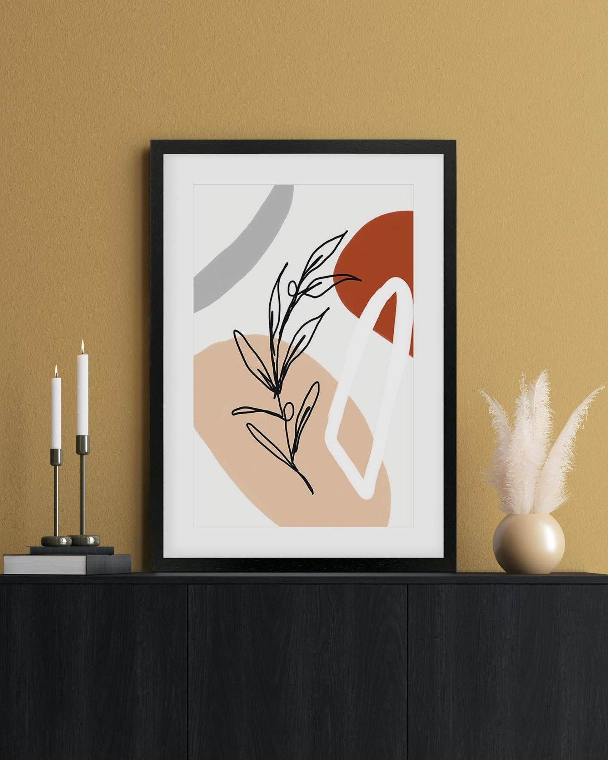 Framed abstract art print on a wall with decorative items below.