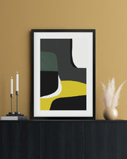 Framed abstract art piece on a wall with candles and decor items.