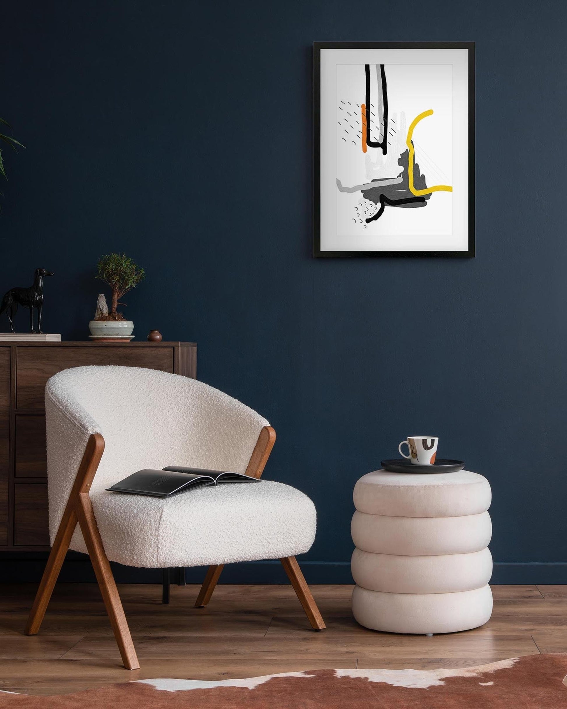 framed abstract print on navy wall above a chair