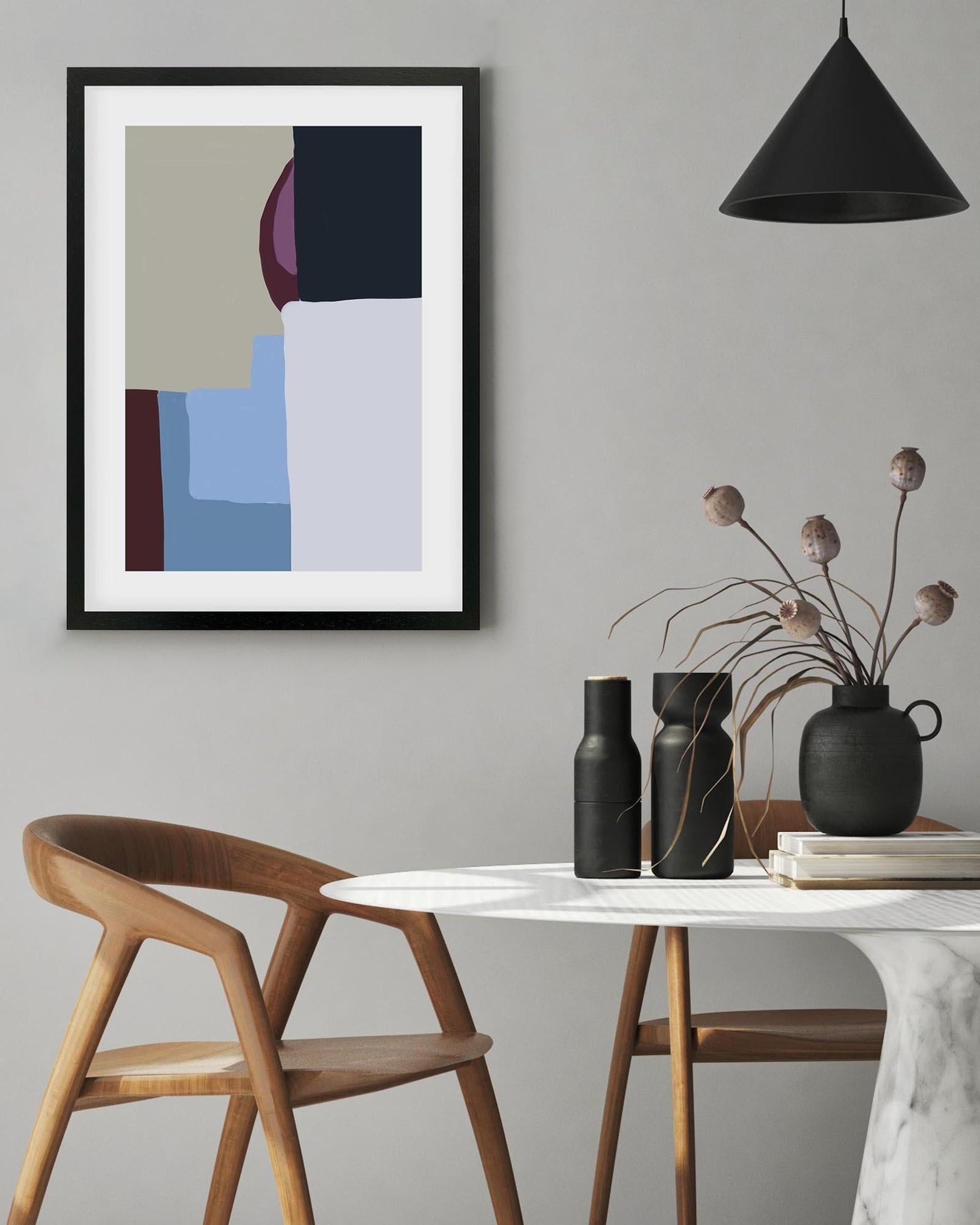 Modern interior with abstract art, wooden chair, and decorative items on a table.