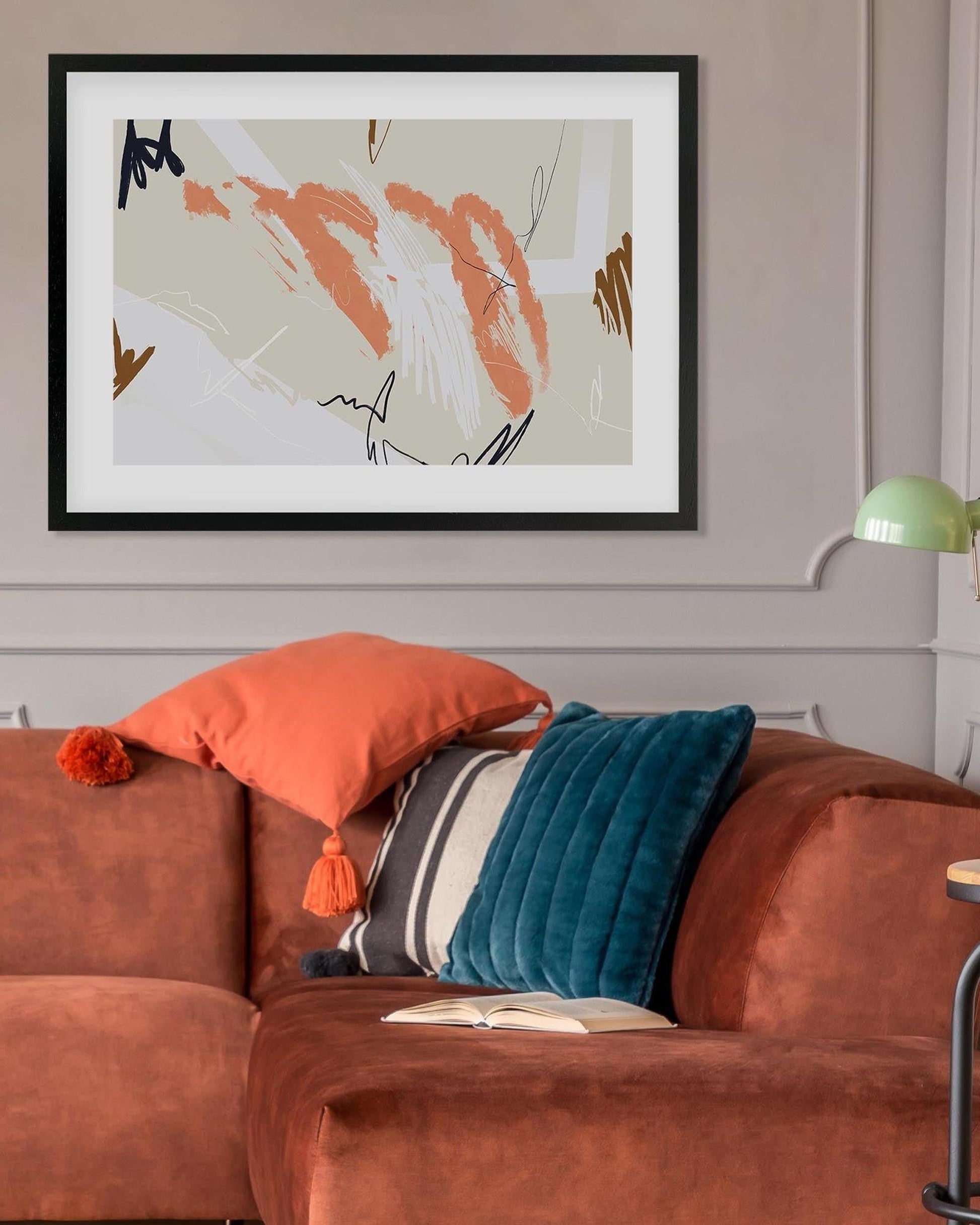 Brown sofa with colorful cushions and a framed abstract painting on the wall.