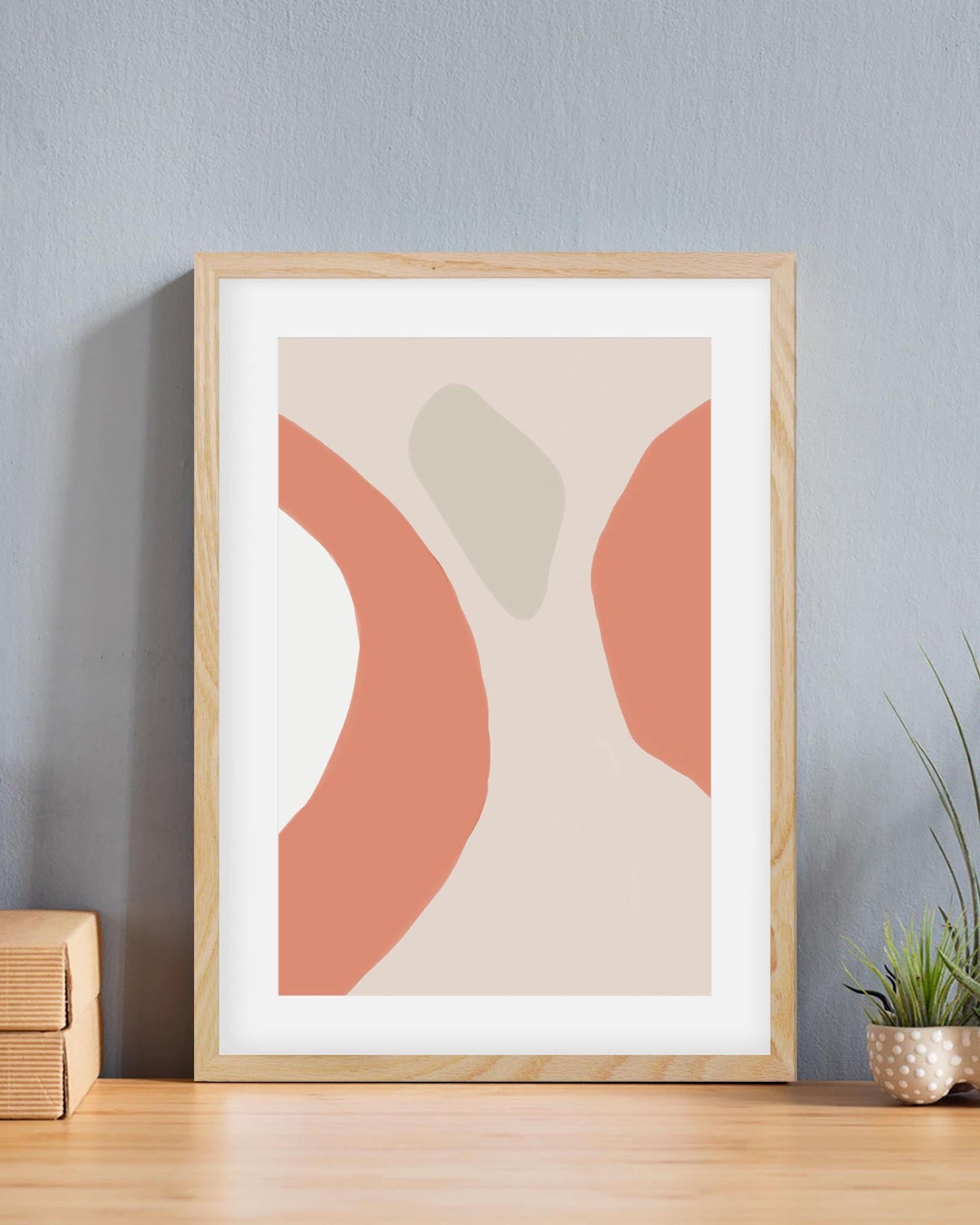 Framed abstract art print with geometric shapes on a wall