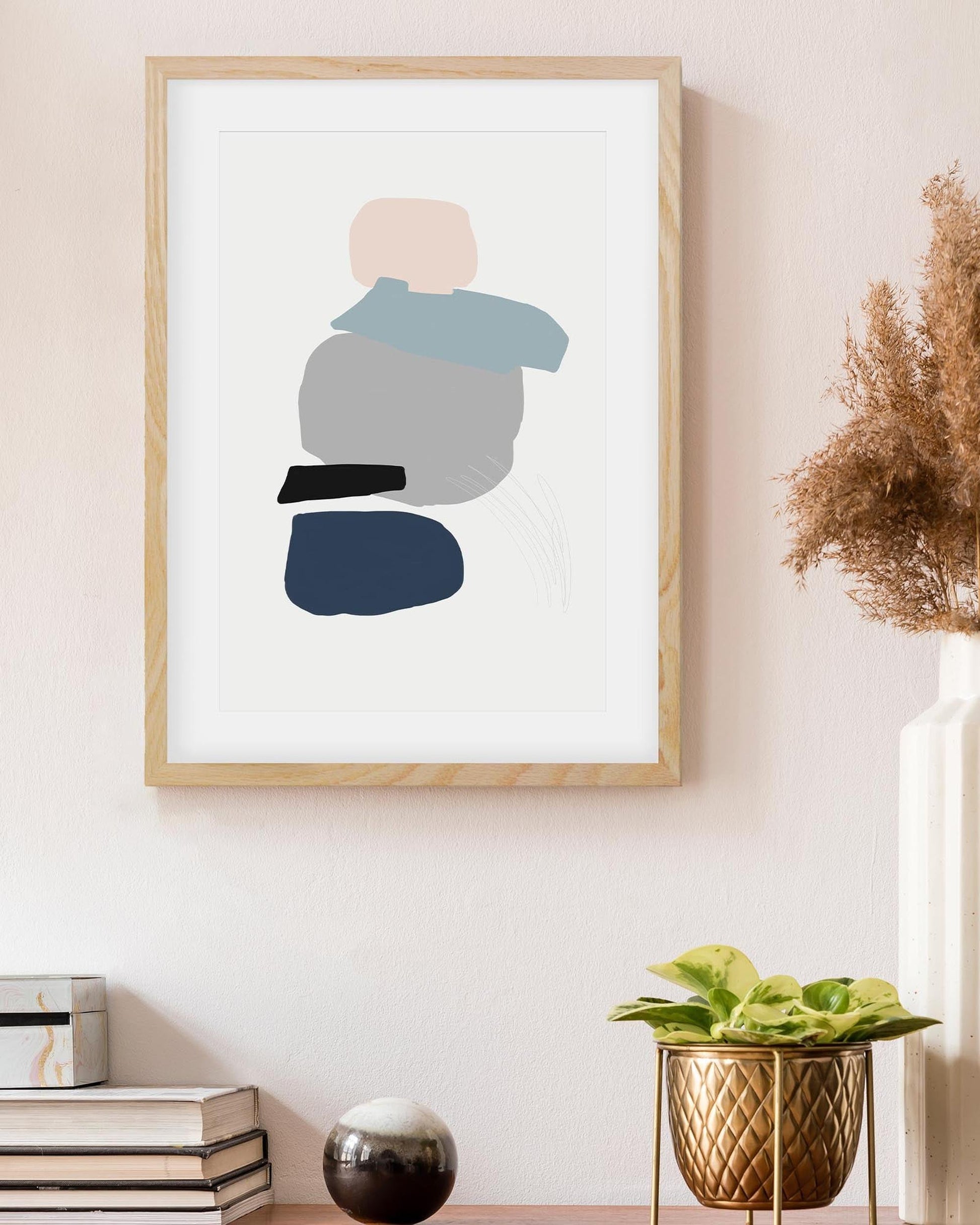 Framed abstract art print on a wall with decor elements below